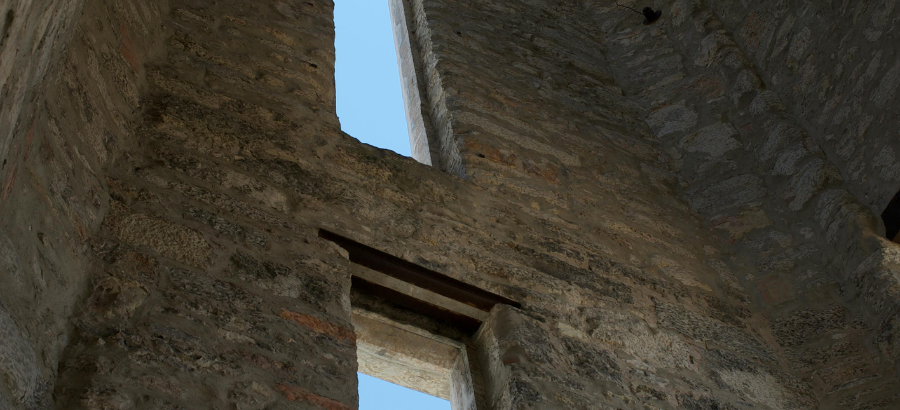 Inside of an old brick building with long, vertical windows}