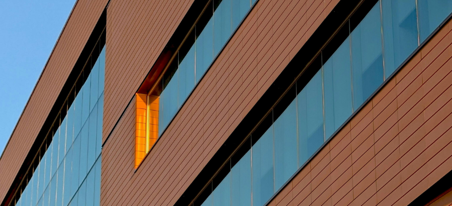 Close-up of an orange building with blue tint windows