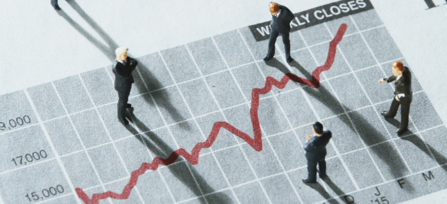 Small human figurines standing on red-lined graph}