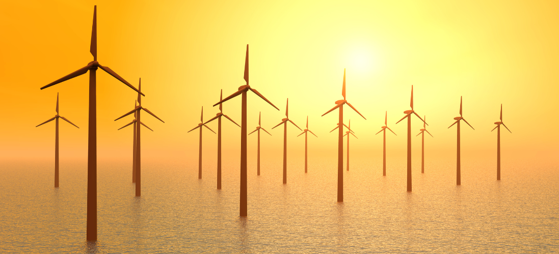 A group of wind mills standing in a body of water at sunset 