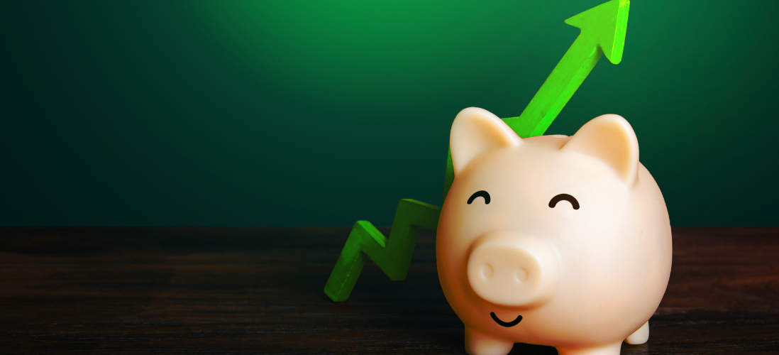 A smiling piggy bank with an arrow showing upward growth behind it 